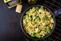 Penne pasta with cabbage romanesco on black table.