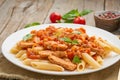 Penne pasta, chicken or turkey fillet, tomato sauce with basil leaves on old rustic wooden background. Close up, side view Royalty Free Stock Photo