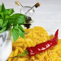 Penne Pasta, green basil, parmesan, sesame, garlic, chilli, eggs lie on a white tree table Royalty Free Stock Photo