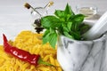 Penne Pasta, green basil, parmesan, sesame, garlic, chilli, eggs lie on a white tree table Royalty Free Stock Photo