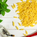 Penne Pasta, green basil, parmesan, sesame, garlic, chilli, eggs lie on a white tree table Royalty Free Stock Photo