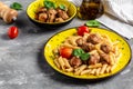 Penne pasta with meatballs and tomato sauce, on a yellow plate and a gray background Royalty Free Stock Photo