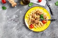 penne pasta with meatballs and tomato sauce, on a yellow plate and a gray background Royalty Free Stock Photo