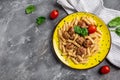 Penne pasta with meatballs and tomato sauce on a yellow plate and a gray background. Culinary, cooking, bakery concept, banner, Royalty Free Stock Photo