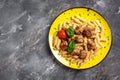 Penne pasta with meatballs and tomato sauce on a yellow plate and a gray background. Culinary, cooking, bakery concept, banner, Royalty Free Stock Photo