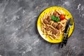 Penne pasta with meatballs and tomato sauce on a yellow plate and a gray background. Culinary, cooking, bakery concept, banner, Royalty Free Stock Photo