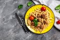 Penne pasta with meatballs and tomato sauce on a yellow plate and a gray background. Culinary, cooking, bakery concept, banner, Royalty Free Stock Photo