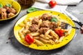Penne pasta with meatballs and tomato sauce on a yellow plate and a gray background. Culinary, cooking, bakery concept, banner, Royalty Free Stock Photo