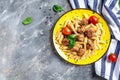 Penne pasta with meatballs and tomato sauce on a yellow plate and a gray background. Culinary, cooking, bakery concept, banner, Royalty Free Stock Photo