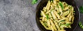 Penne pasta with pesto sauce, zucchini, green peas and basil. I