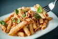Penne pasta with a spicy sauce, basil and parmesan
