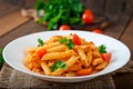 Penne pasta in tomato sauce with chicken, tomatoes decorated with parsley Royalty Free Stock Photo