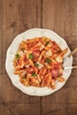 Penne pasta with tomato sauce, fork and spoon plunged into plate