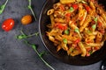 Penne pasta in tomato sauce with meat, tomatoes decorated with pea sprouts