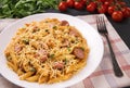 Penne pasta in tomato sauce with sausages and cheese, decorated with parsley on a  black background Royalty Free Stock Photo