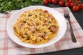 Penne pasta in tomato sauce with sausages and cheese, decorated with parsley on a  black background Royalty Free Stock Photo