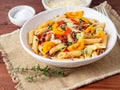 Penne pasta with yellow tomatoes, red and green vegetables, minc