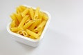 Penne rigate pasta in the plastic box Royalty Free Stock Photo