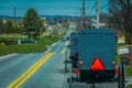 Pennsylvania, USA, APRIL, 18, 2018: View of the back of an old fashioned, Amish buggy with a horse riding on gravel