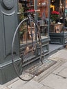 Penny farthing bicycle chained up parked outside a store in london
