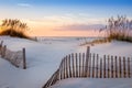 Photo of a sunrise at Pensacola Beach, Florida with beautiful white dunes, sea oats and a dune fence