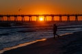 Pensacola Beach pier at sunset with a silhouette of a man