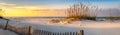 Panoramic photo of a beautiful sunrise at Pensacola Beach Florida with sea oats dunes, and a board fence