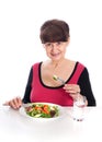 Pension age good looking smiling woman eating green salad Royalty Free Stock Photo