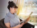 Pension age good looking woman reading the news paper Royalty Free Stock Photo