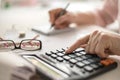 Pension calculation concept, old hands counting finances on a home calculator , close- up Royalty Free Stock Photo