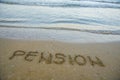 Pension written on sand by sea at beach. Royalty Free Stock Photo