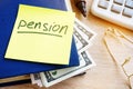 Pension written on a stick and money. Retirement savings.