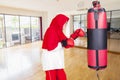 Pensioner female punching boxing sacks in the gym