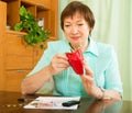 Pensioner looking at bills and counting money Royalty Free Stock Photo