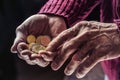 Pensioner man holding in hands euro coins. Theme of low pensions Royalty Free Stock Photo