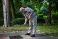 Pensioner starts to shot a minigolf ball at the court