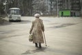 Pensioner with walking stick in city. Old lady on street. Elderly woman goes home Royalty Free Stock Photo