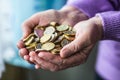 Pensioner woman holding in hands euro coins. Theme of low pensions