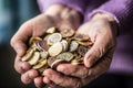 Pensioner woman holding in hands euro coins. Theme of low pensions Royalty Free Stock Photo