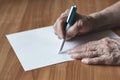 Pensioner writes in pen on paper Royalty Free Stock Photo