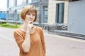 Pensive adult woman stands on the street Royalty Free Stock Photo