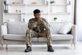 Pensive african american soldier in military uniform sitting on couch Royalty Free Stock Photo
