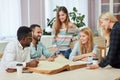 Diverse multiracial students spending leisure time in library with big old book Royalty Free Stock Photo