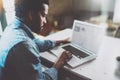 Pensive African man working on laptop while spending time at home.Concept of young business people using mobile devices Royalty Free Stock Photo