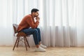 Pensive Arab man sitting on chair and thinking Royalty Free Stock Photo