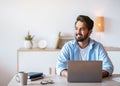 Pensive Arab Man Sitting At Desk With Laptop In Home Office Royalty Free Stock Photo