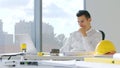 Pensive architect looking at laptop screen sitting at table working at office Royalty Free Stock Photo