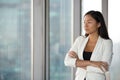 Pensive Asian female employee think of problem solution