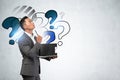 Pensive Asian man with clipboard, question marks Royalty Free Stock Photo