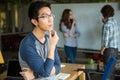 Pensive asian man in glasses thinking and working with colleagues Royalty Free Stock Photo